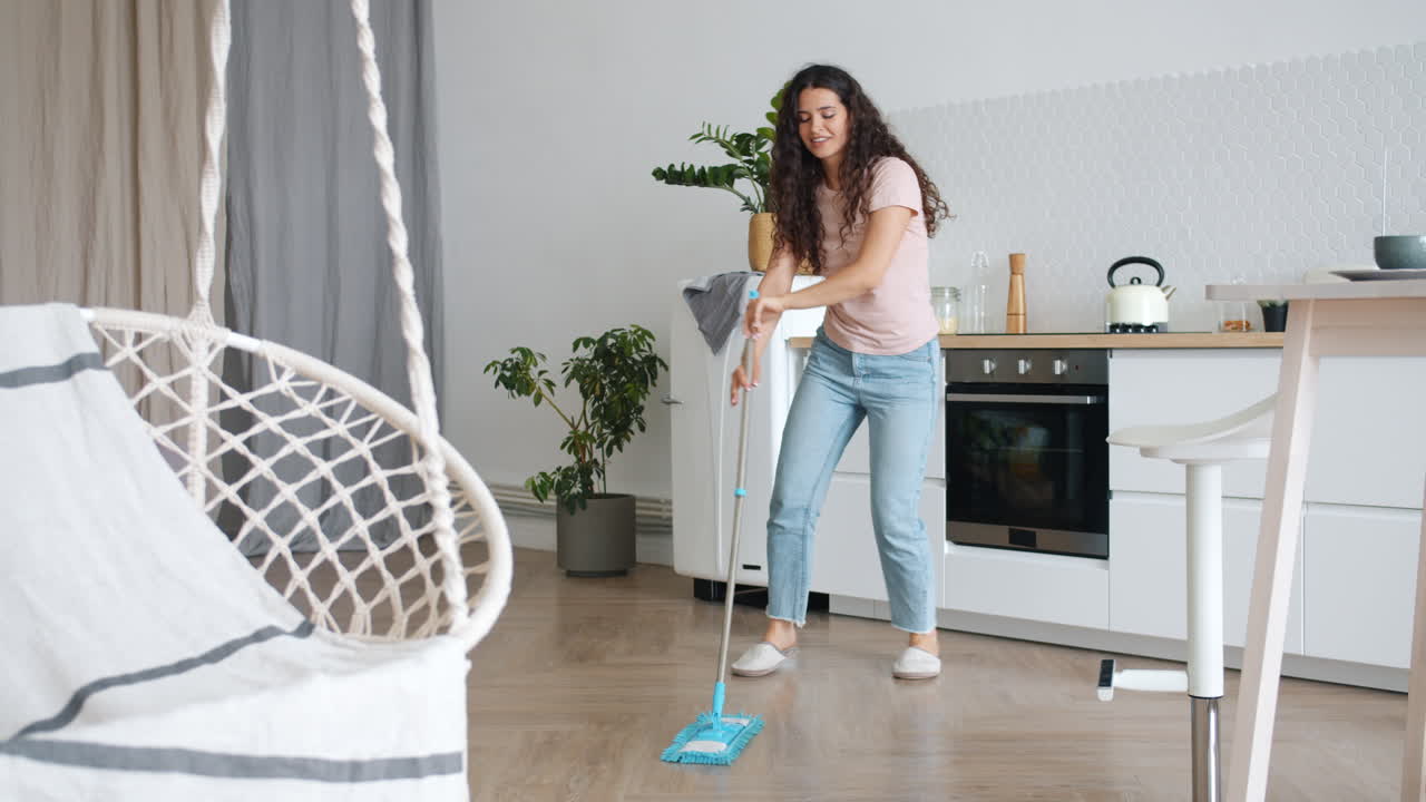 Woman Dancing While Mopping the Kitchen Floor