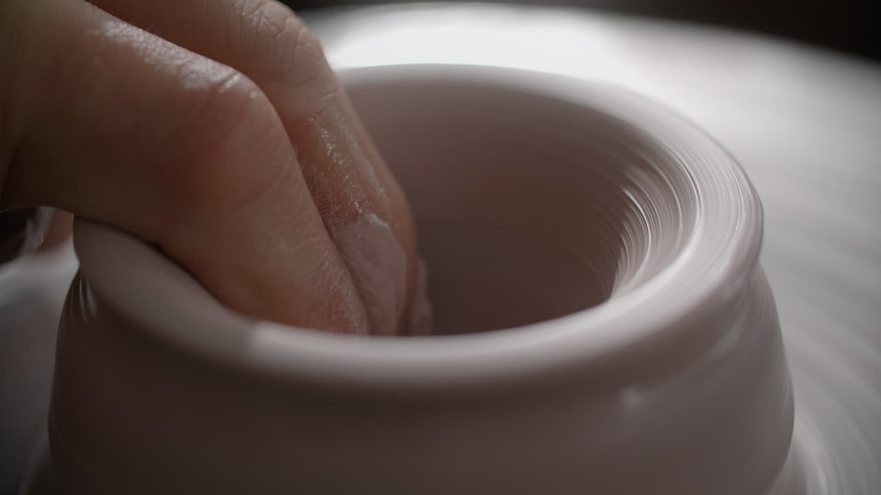 manos moldeando arcilla en una rueda de cerámica