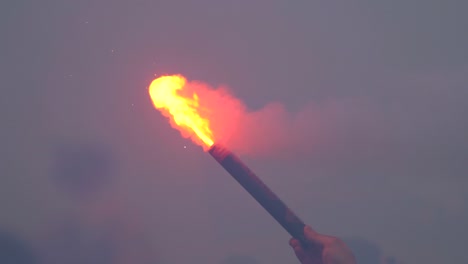 close-up of a burning signal flare held by a man in 4k slow motion 60fps