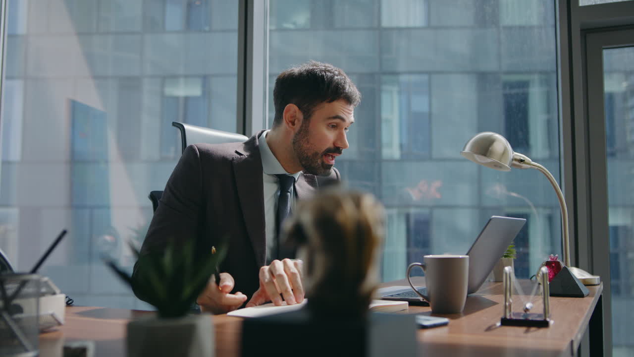 un uomo d'affari che condivide notizie in videoconferenza guardando un computer portatile da vicino.