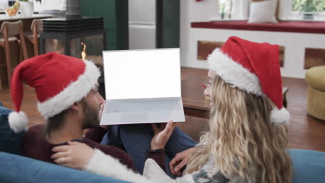 happy caucasian couple having christmas laptop video call with copy space, slow motion