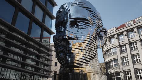 the iconic statue of kafka installed outside quadrio shopping centre, prague, czech republic, tilt up shot