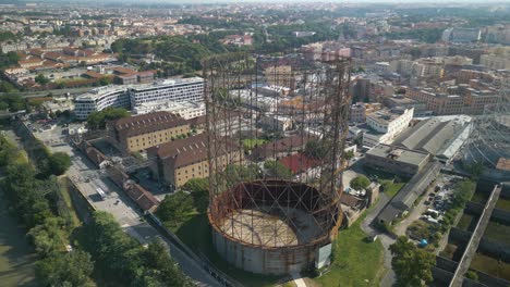 un avión no tripulado girando sobre una estructura de hierro gazómetro en el distrito de ostiense de roma, italia en un día soleado