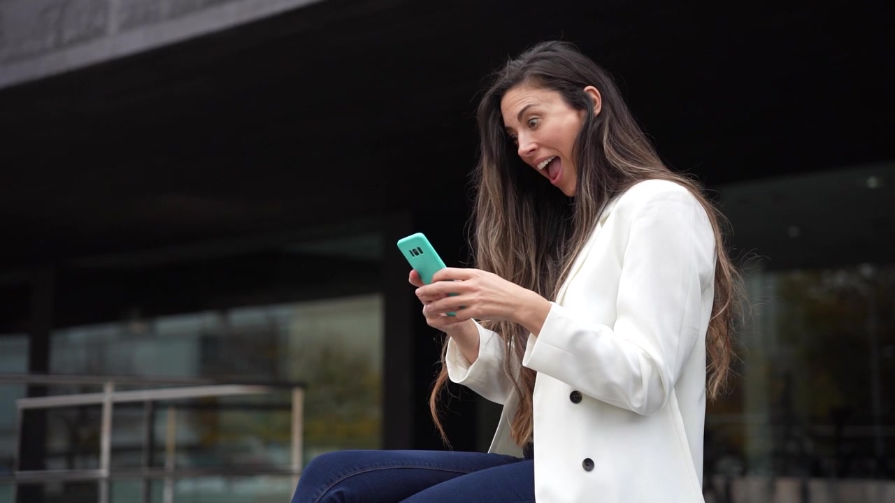 Una giovane donna è intenta al suo smartphone mentre si gode l'aria aperta in città.