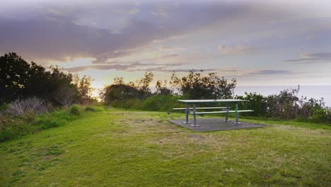 empty picnic table with scenic view of ocean during sunrise - crescent head - sydney, new south wales, australia