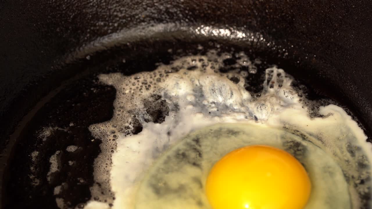 Cracking two eggs into a cast iron pan