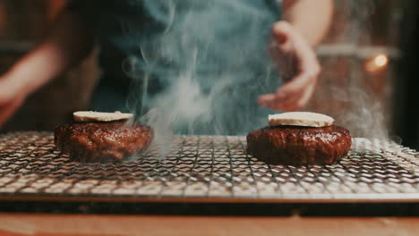 El-Chef-Agrega-Rebanadas-De-Mantequilla-Hechas-A-Mano-Encima-De-Las-Hamburguesas-De-Carne,-Asadas-En-Una-Parrilla-Ahumada-Caliente