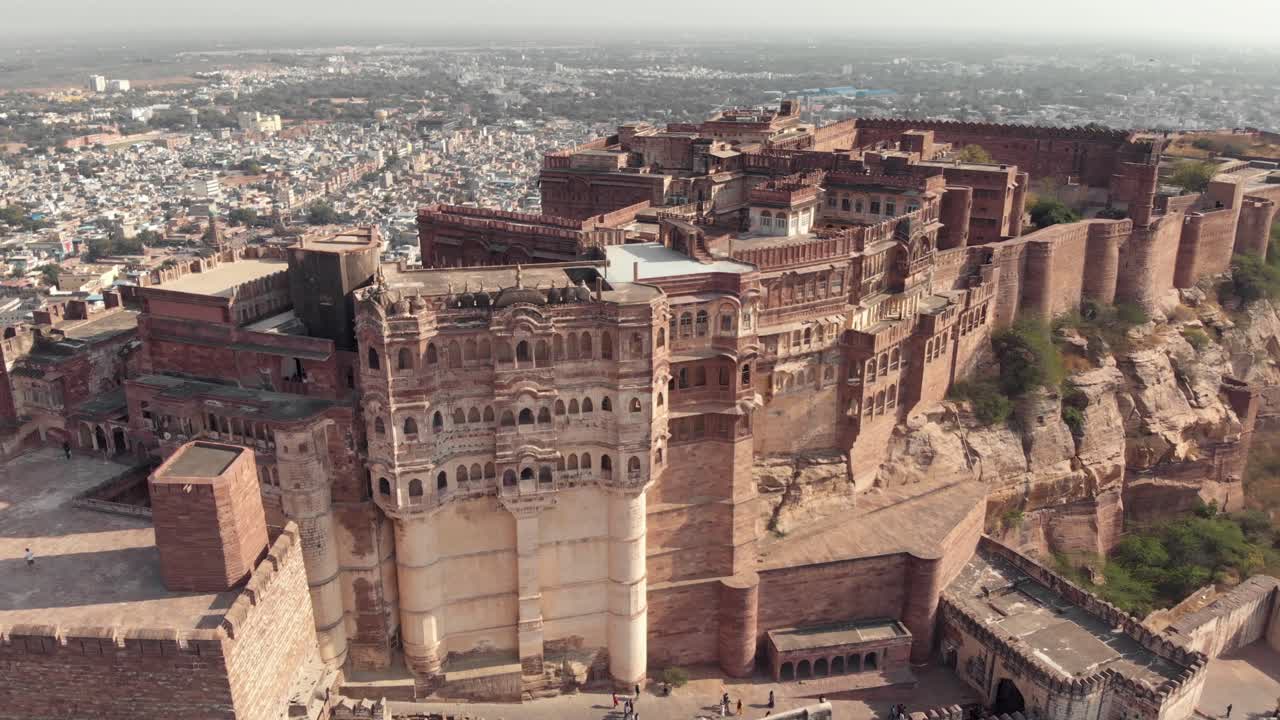 imágenes aéreas de drones inclinando un gran palacio en la cima de una colina sobre la vasta ciudad de jodhpur, india