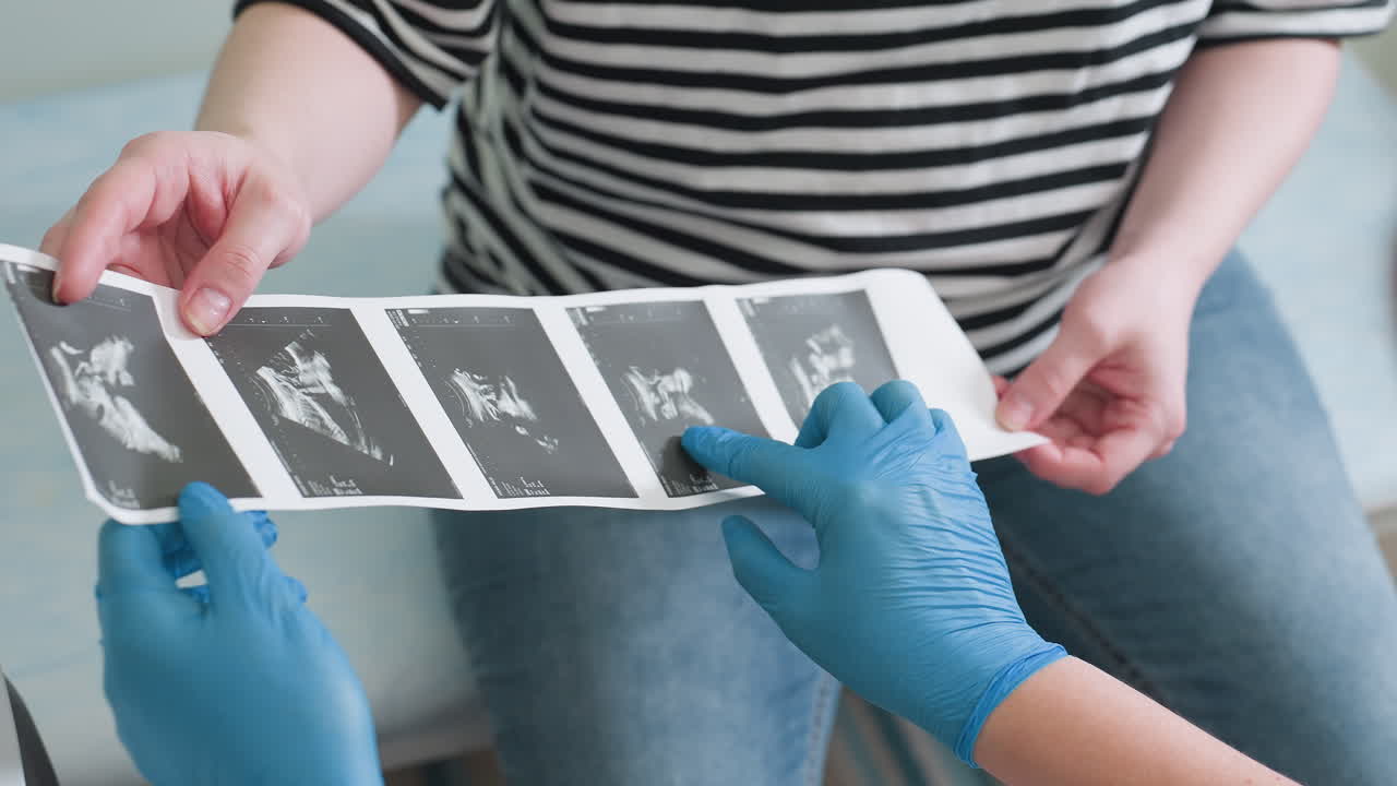 Radiologist carefully explains each ultrasound image to her patient, pointing at each scan result individually, making sure the patient understands the findings with a clear, detailed explanation