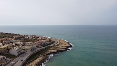 drone vuela a un punto de descanso para surfear en sicilia en italia, autos conduciendo en la carretera de la costa