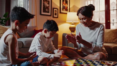 grandmother playing a board game with grandchildren