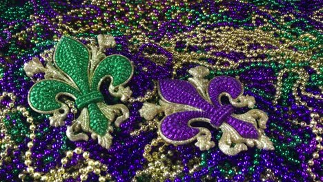 구슬 더미에 녹색과 보라색의 반짝이는 fleur de lis