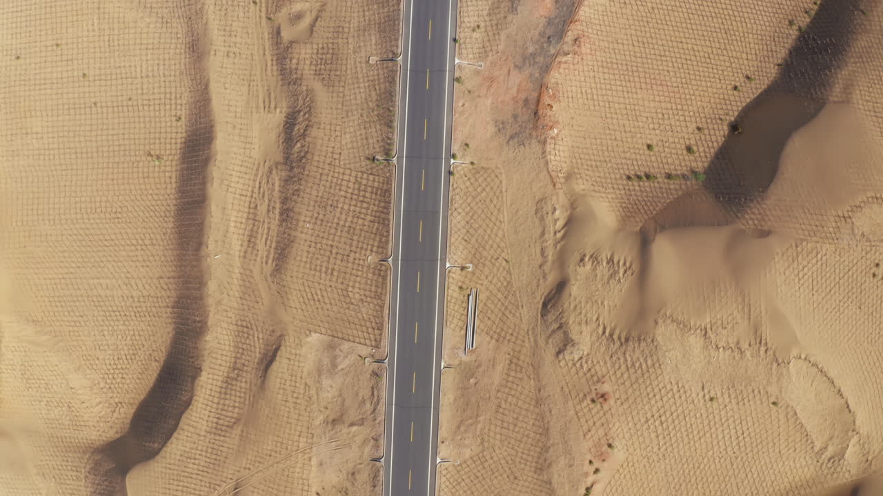 보호 를 위해 모래 울타리 로 둘러싸인 고비 사막 의 고속도로 의 위 에서 아래 로 보이는 모습