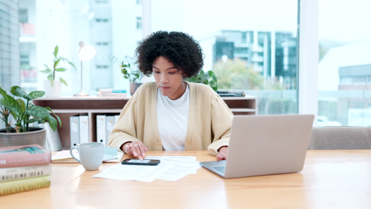 Donna, telefono e laptop per il budget