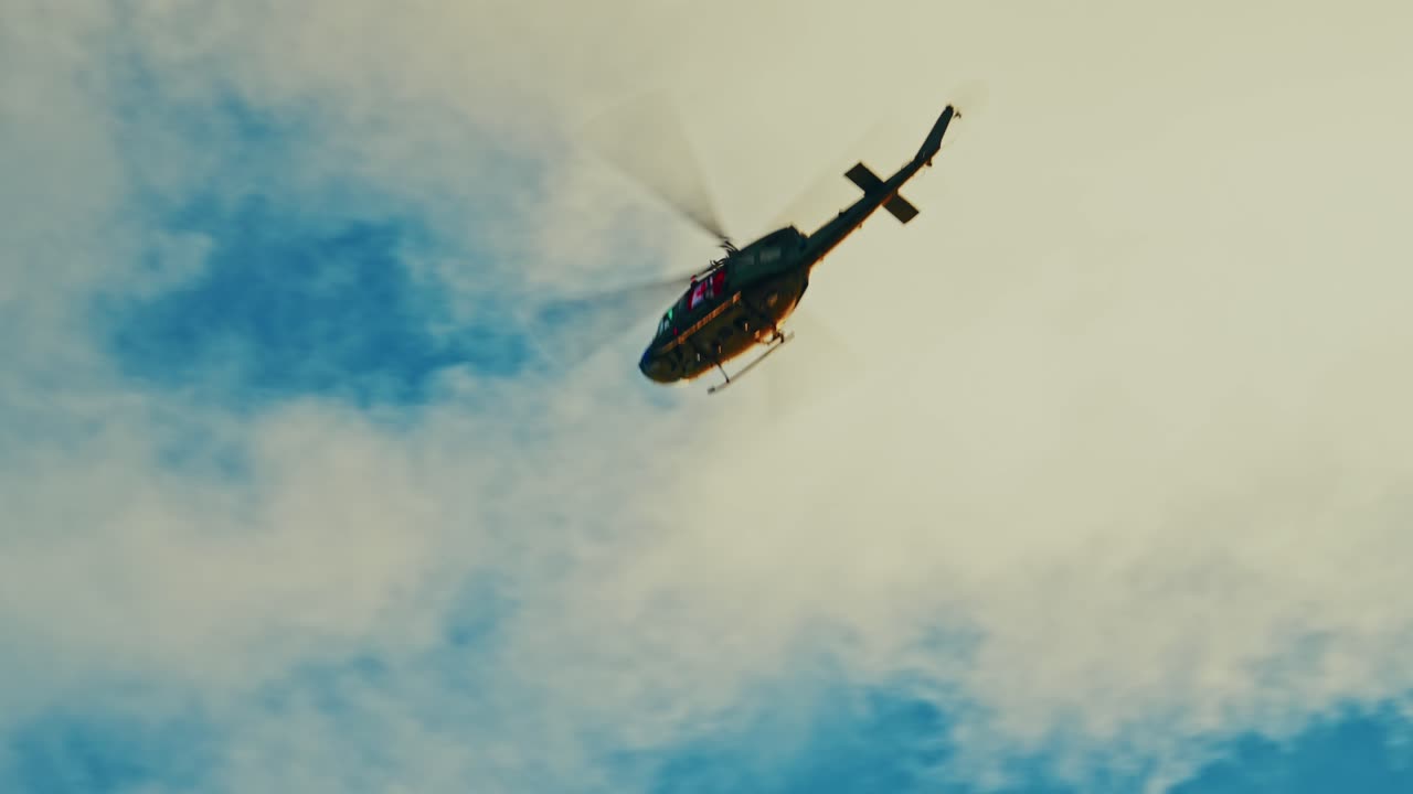 Uma poderosa tomada grande-angular de quatro helicópteros militares UH-60 Black Hawk voando em formação tática contra um céu azul nublado. Esta filmagem cinematográfica representa cooperação militar.