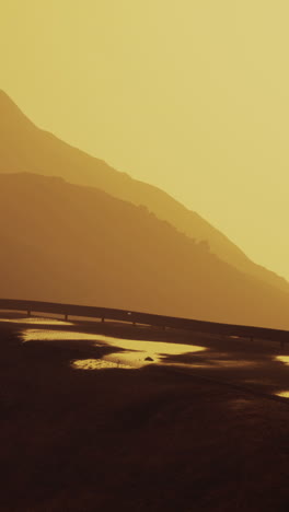 sunset over desert mountains with highway bridge