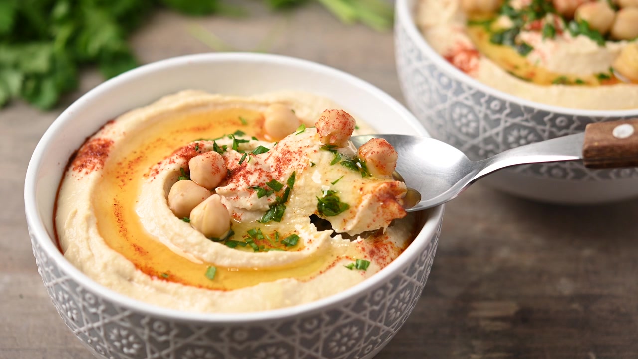 Video di hummus di ceci con olio d'oliva, prezzemolo e paprika in ciotola