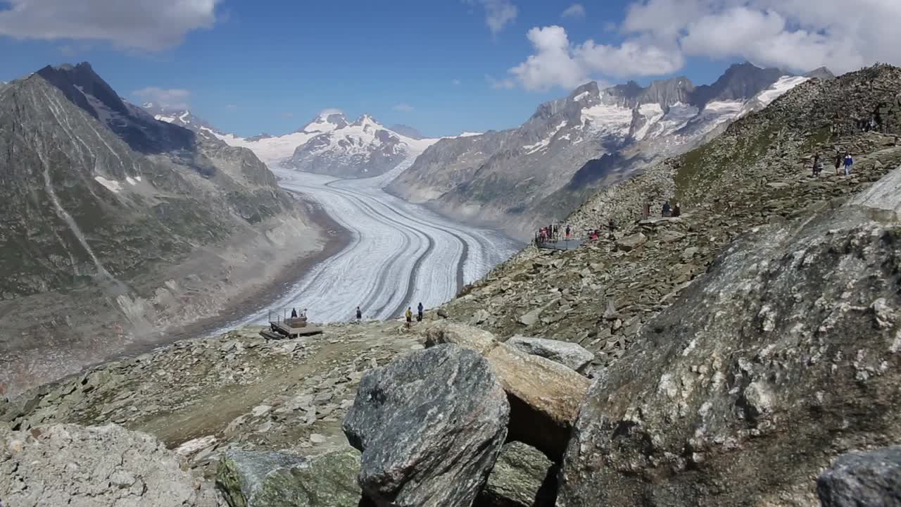 People hiking on trail with awesome panorama on Aletsch glacier, Switzerland