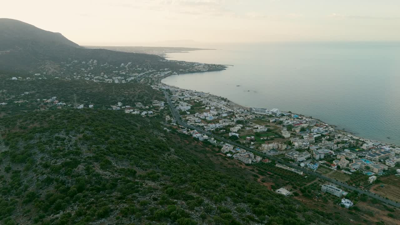 Aerial - expansive view of Chersonissos Bay with coastal town in Crete Greece