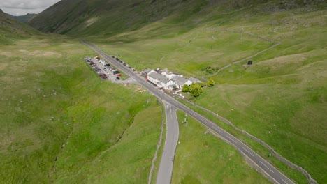 the kirkstone pass inn next to the a592 and busy car park. summer. cloud shadows moving over landscape. lake district, cumbria, uk