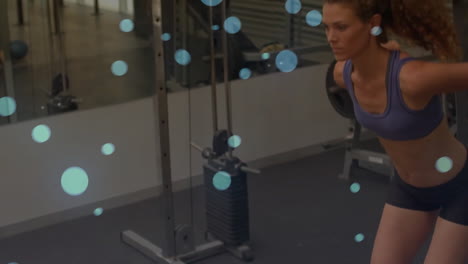 exercising in gym, woman with blue dots animation over workout equipment