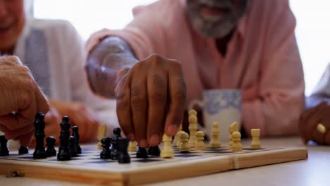personas mayores activas de raza mixta jugando al ajedrez en el asilo de ancianos 4k