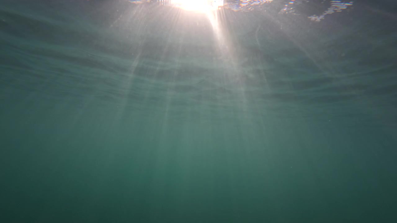 Vista subacquea verso la superficie illuminata dal sole con raggi di luce che filtrano attraverso l'acqua, Golfe-Juan, Francia