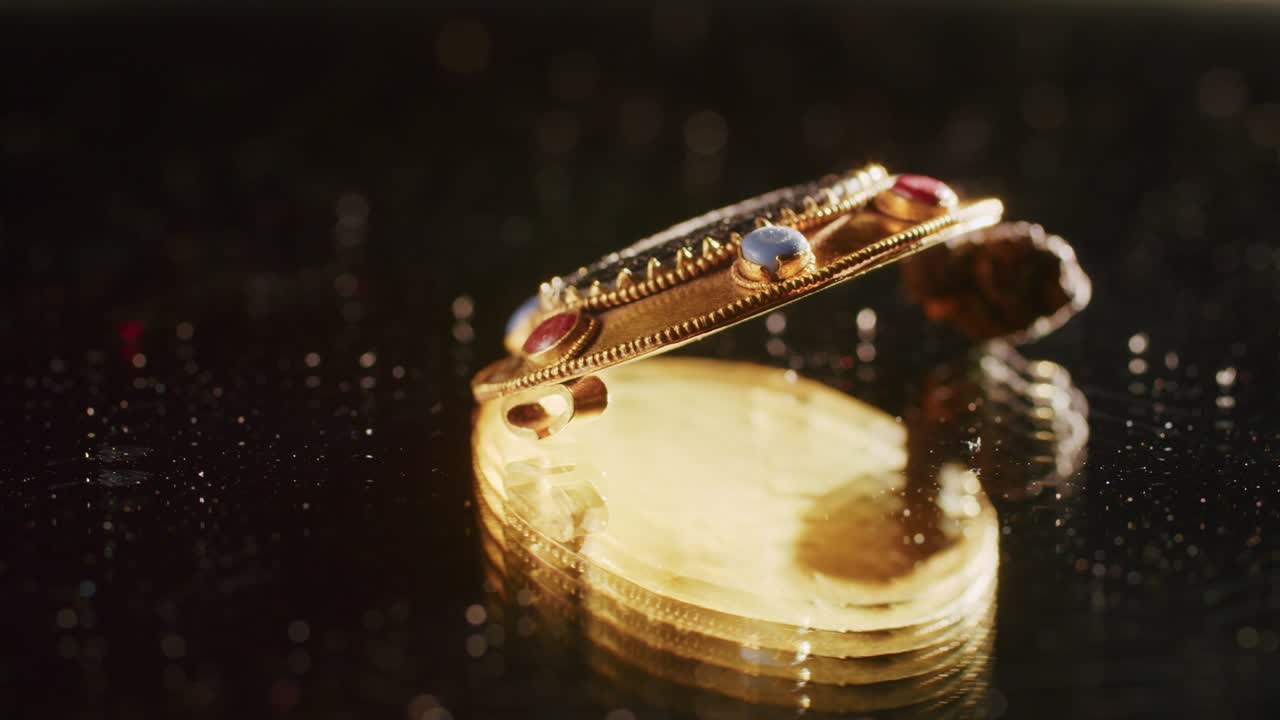 Eine 2000 Jahre alte Goldbrosche einer skythischen Priesterin, ein alter Ohrring, ein Spinnrad, bei Ausgrabungen gefunden. Vintage-Schmuck. Religion. Nahaufnahme.