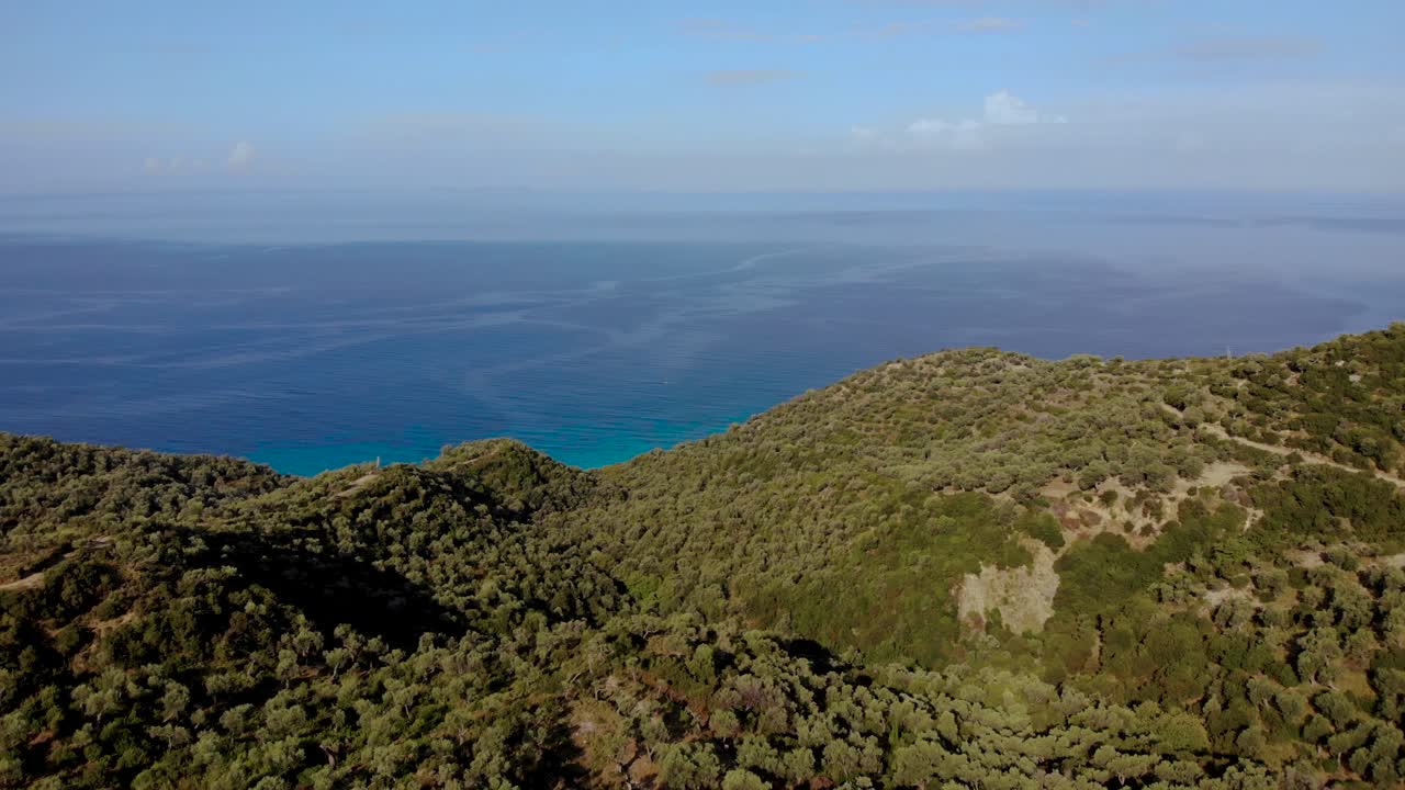 vista panorámica del paisaje marino de colinas verdes con olivos y fondo azul marino en albania