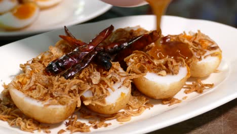 Close-up-Footage-of-Son-In-Law-Egg-,-Deep-Fried-Egg-with-Sweet-and-Sour-Tamarind-Sauce,-Topping-with-Dried-Chilli,-Thai-Famous-Dish