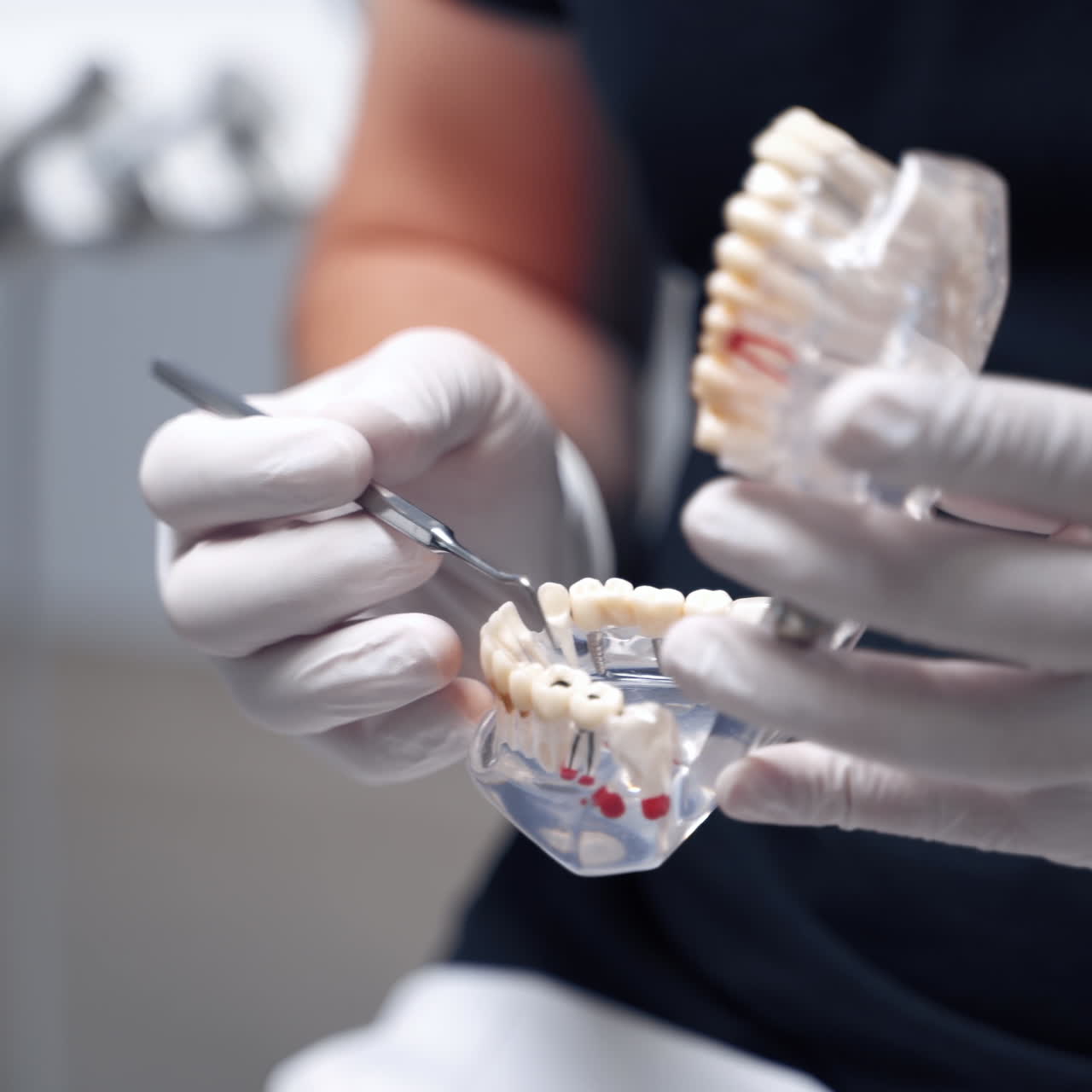 Dentist holding artificial jaw at the dental office. Doctor in gloves shows teeth by medical tool on a jaw mock. Close-up.