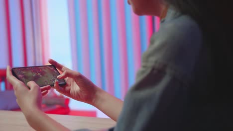 hands girl gamer playing video game on mobile phone