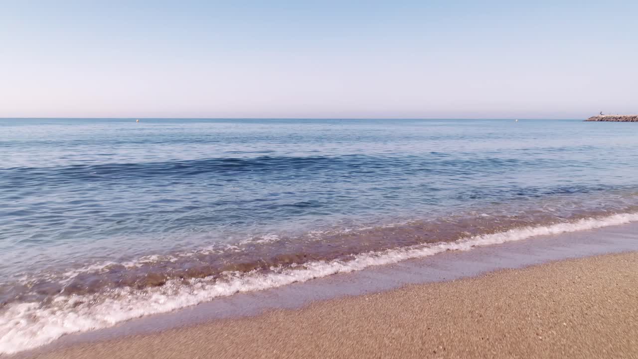 Cabopino plajının kıyı şeridi, plajdan denize doğru havadan ileri hareket eden görüntü.