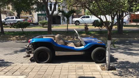 custom made 4x4 blue beach dune buggy parked on busy downtown city street