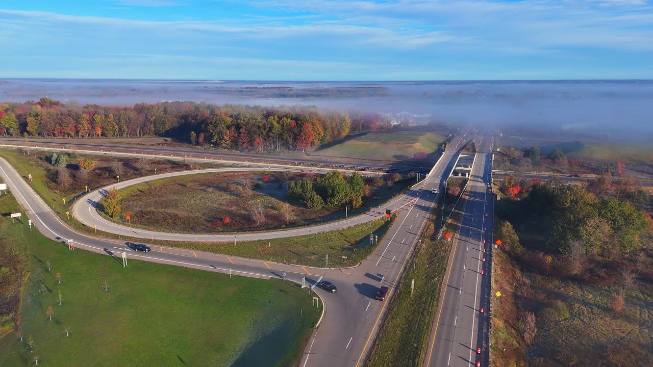 Jalan keluar I-96 di Lake Odessa, Michigan, AS dengan warna musim gugur dan kabut pagi