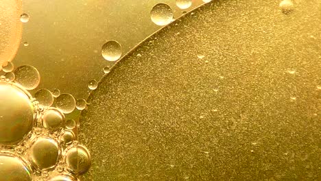 swirling and merging gold oil bubbles background