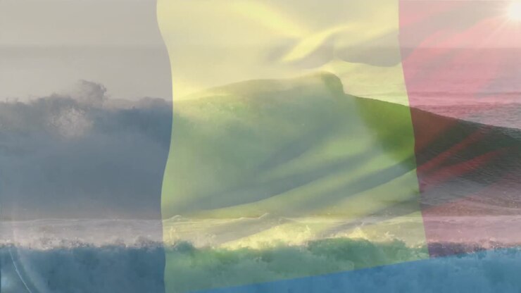 Digital komposition af Belgiens flag vajende mod et luftfoto af bølger i havet