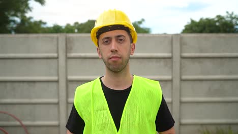 A-Construction-Worker,-Wearing-a-Yellow-Hard-Hat,-Removes-His-Standard-Safety-Glasses---Medium-Close-Up