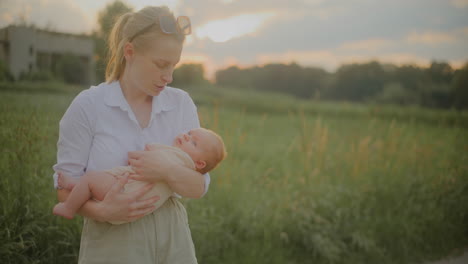 happy mother holding baby at sunset