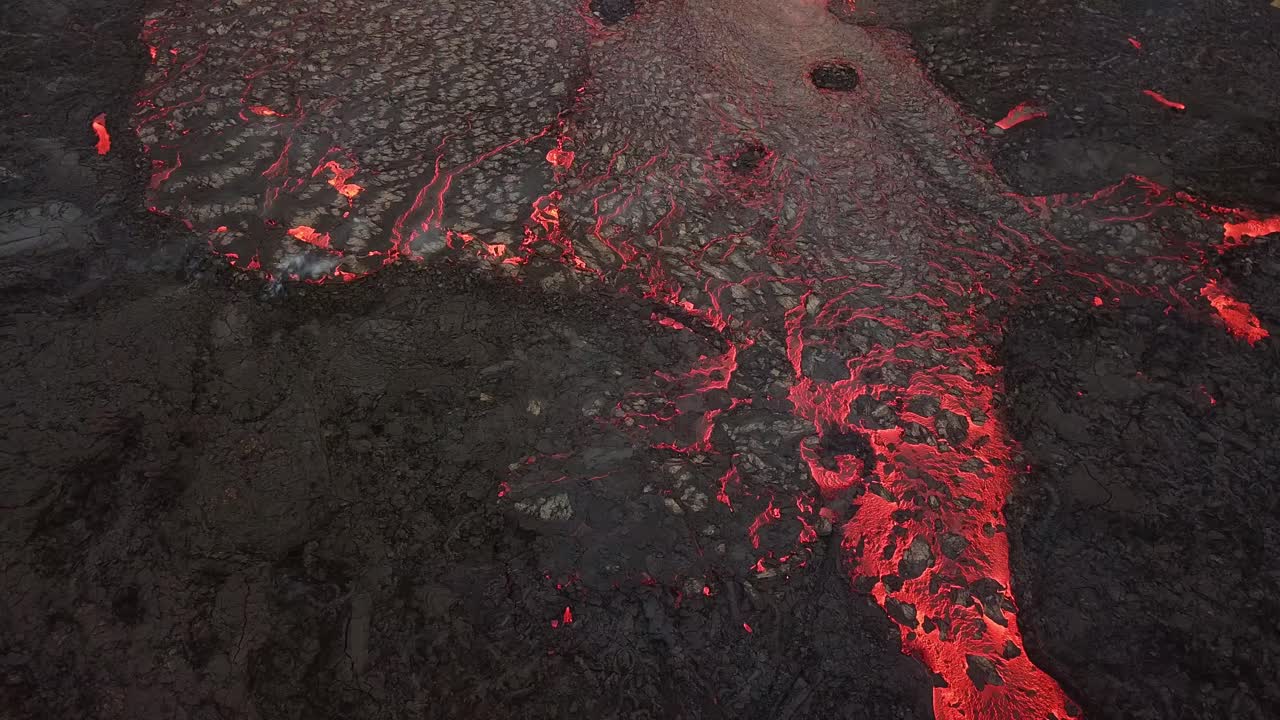 vista aérea de un río de lava que fluye a través del valle de meradalir, islandia, saliendo del volcán fagradalsfjall