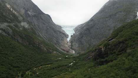 large glacier in a green valley, big forrest with mountains, briksdalsbreen, norway, nature, drone