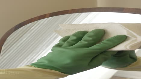 cleaning a mirror with gloves