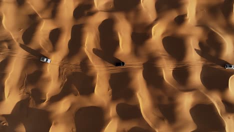 El-Dron-Está-Volando-Mirando-De-Arriba-Hacia-Abajo-A-Tres-Autos-Conduciendo-Por-El-Desierto-Del-Sahara-En-Imágenes-Aéreas-De-Túnez-4k