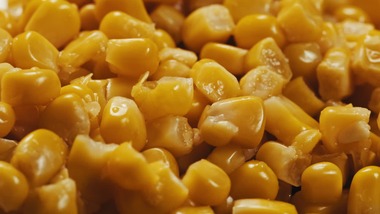 Canned corn rotating on dark background. Close up on opened aluminum can with corn. High quality 4k footage