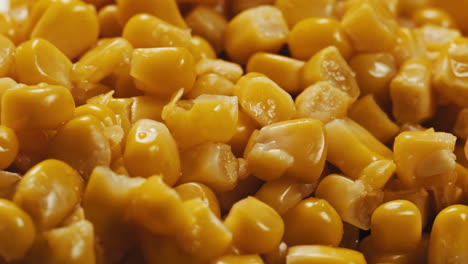 canned corn rotating on dark background. close up on opened aluminum can with corn. high quality 4k footage