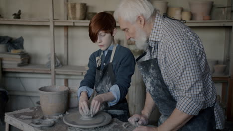 grandfather teaching grandson pottery