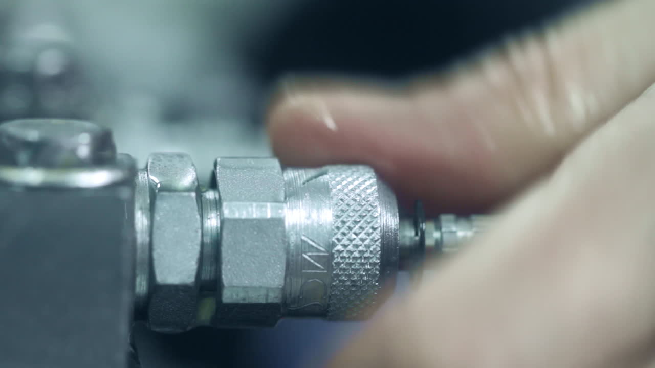 trabajador desenroscando la manguera de la unidad. ingeniero trabajando con mangueras hidráulicas de presión