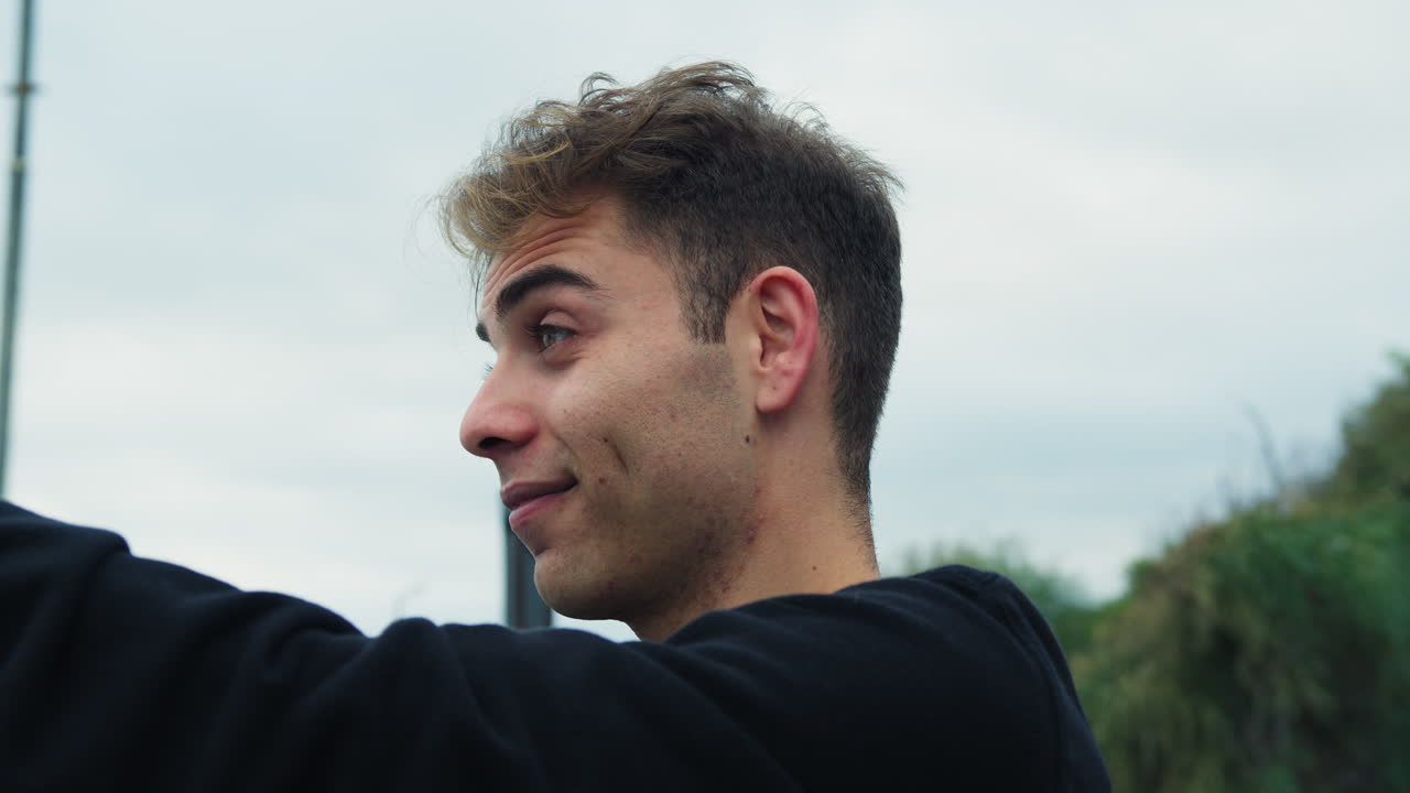 niño se toma una selfie con el teléfono afuera en un parque sonriendo