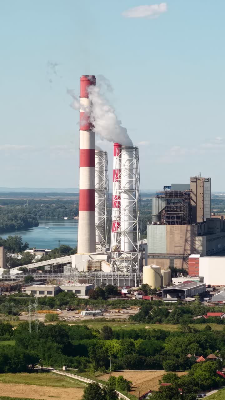Coal Fired Power Station, Electric Plant by River, Smoking Chimneys, Vertical Drone Shot