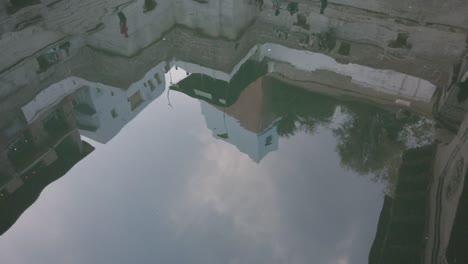 ingeniosa toma de agua que refleja los edificios de arriba en el pozo escalonado toorji ka jhalra, jodhpur, rajasthan